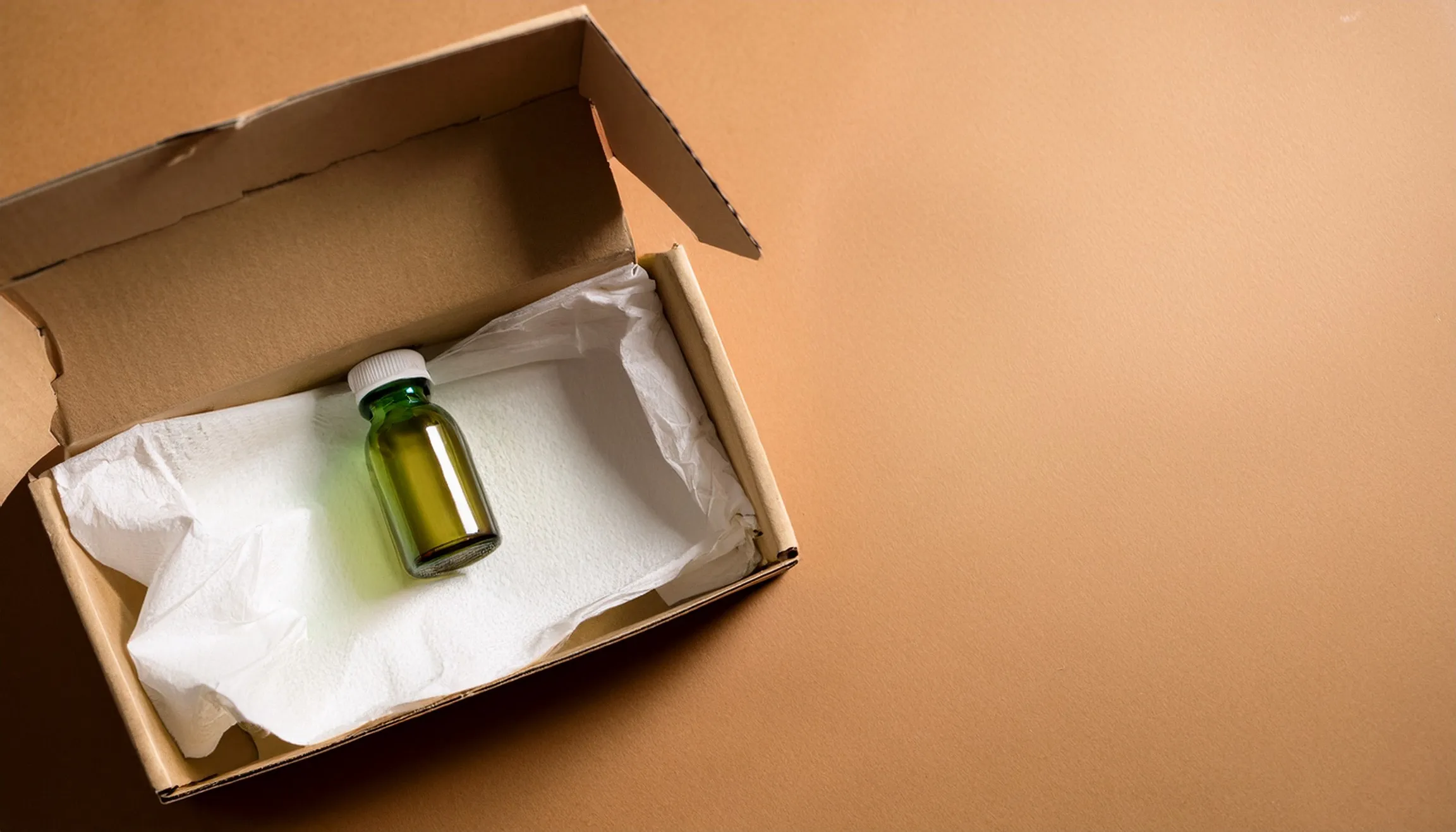 Sliver shipping box opened, with a vial wrapped in tissue