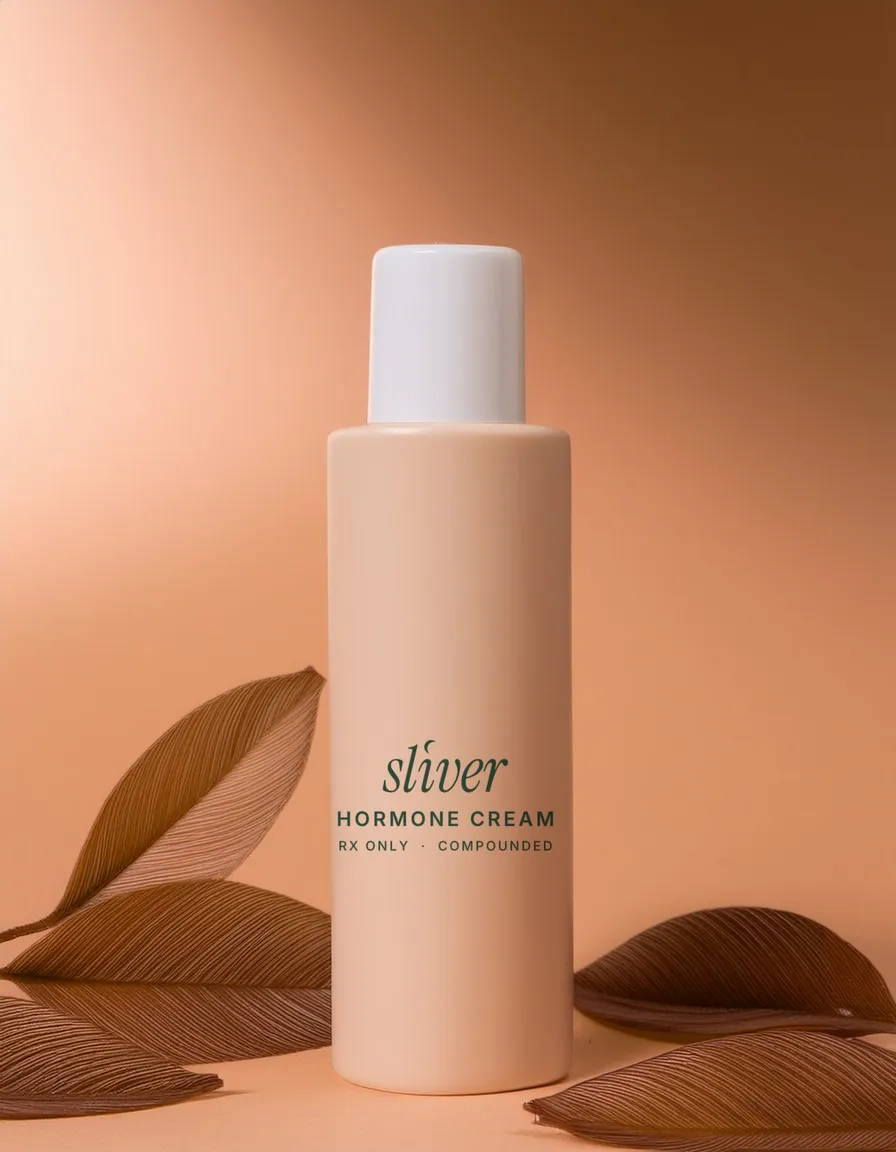 Sliver hormone cream pump bottle on a peach background with dried leaves